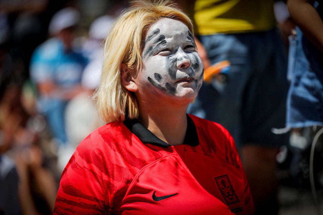 Una fanática surcoreana se reúne con aficionados uruguayos para ver la transmisión del partido entre Uruguay y Corea del Sur en el Mundial de la FIFA Qatar 2022 hoy, en Montevideo (Uruguay). EFE/Raúl Martínez