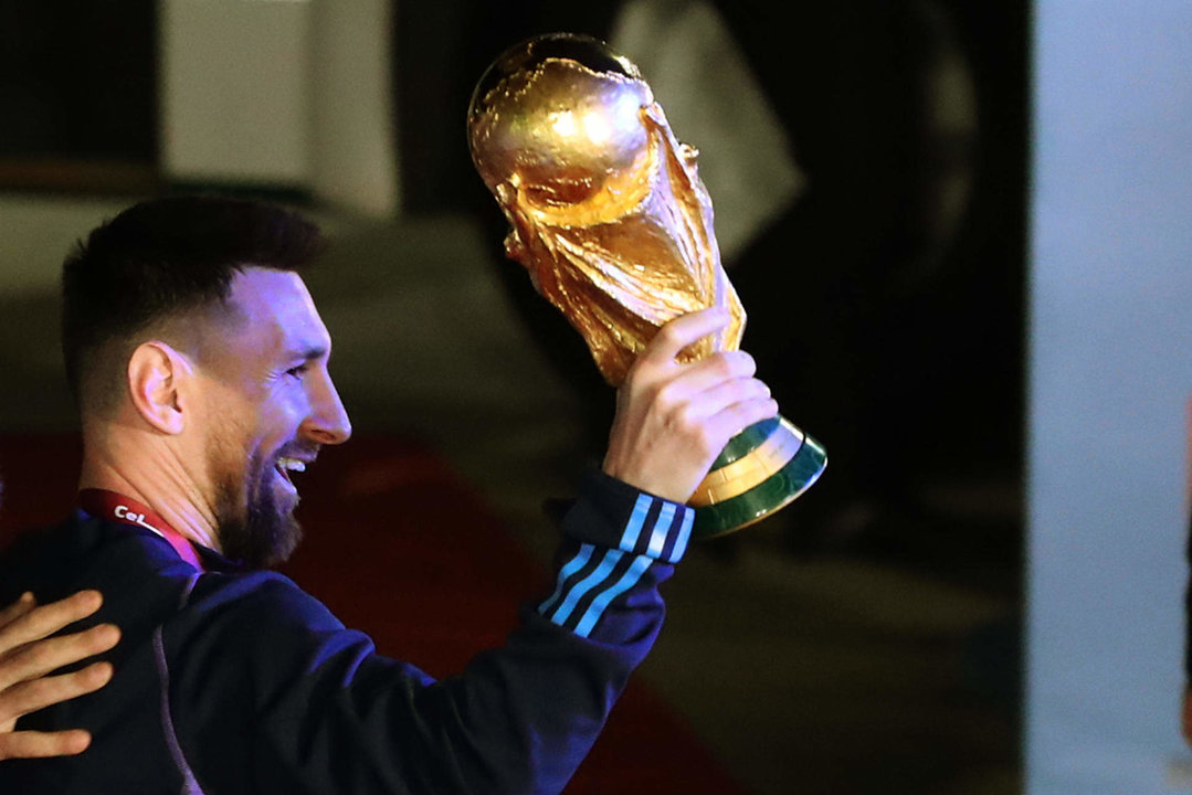 Lionel Messi, capitán de la selección argentina, saluda con el trofeo del Mundial de Fútbol Qatar 2022 a su llegada al Aeropuerto Internacional de Ezeiza. EFE/ Raúl Martínez