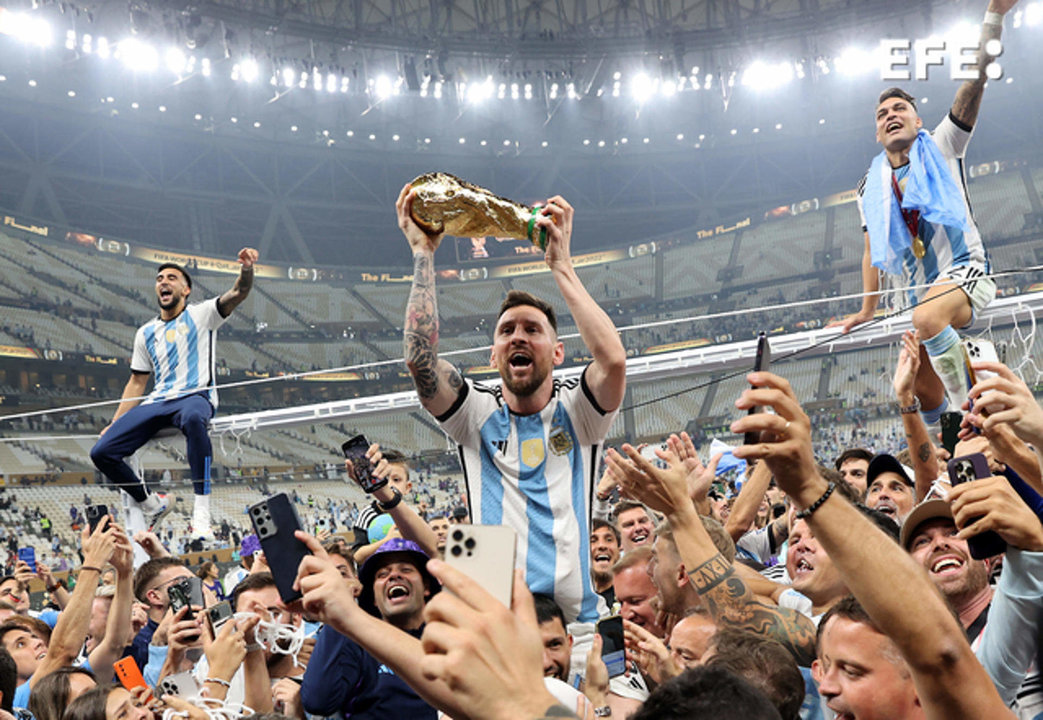 Lionel Messi (c) alza el trofeo del campeones del Mundial de Qatar 2022 después de que Argentina se impusiera a Francia en la final celebrada en el Lusail stadium, el 18 de diciembre. EFE/Tolga Bozoglu